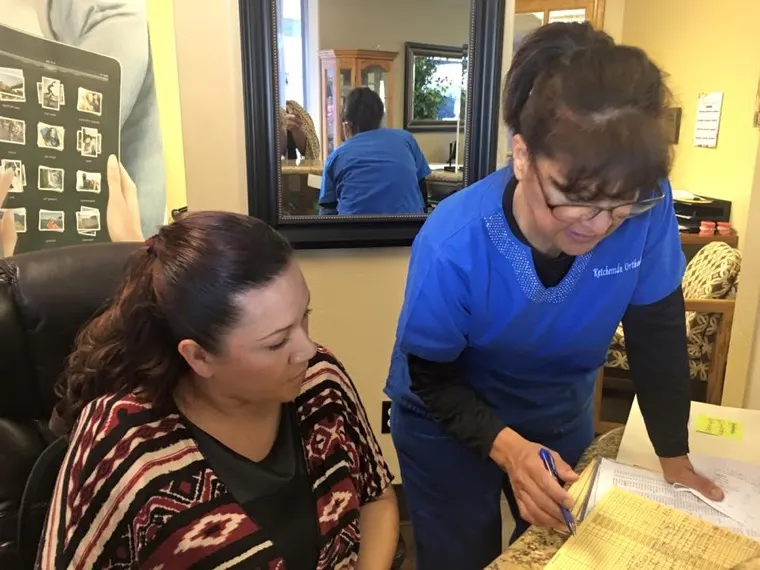 A team member helping a patient at the front desk